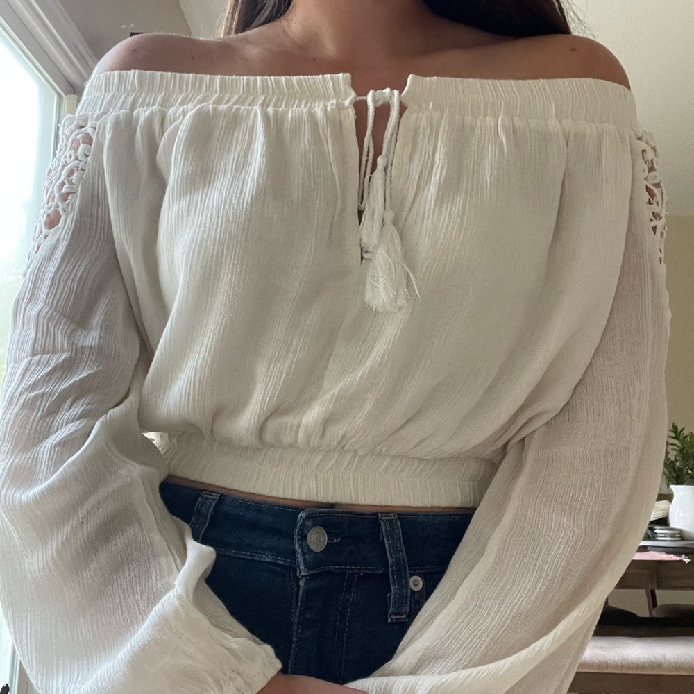 White, over the shoulder crop top with detailed sleeves.